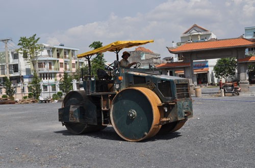 Công nhân xe lu Nguyễn Thành Trung tích cực hoàn thành công đoạn làm sân trước cổng chính khu kưu niệm