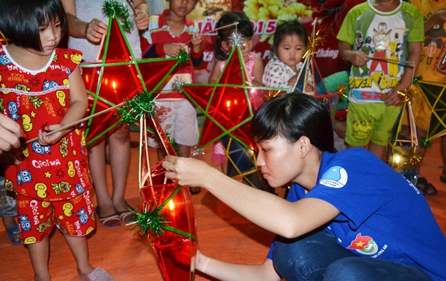 Thanh niên tình nguyện giúp các em thắp sáng lồng đèn.