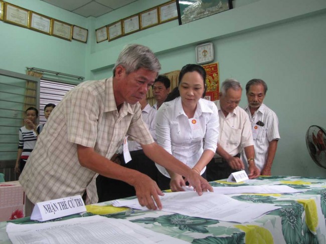 Thành viên tổ bầu cử số 1 khu phố Xuân Hòa 1, phường 6, TP.Tân An kiểm tra danh sách cử tri trước giờ khai mạc.   Ảnh: Mai Hương