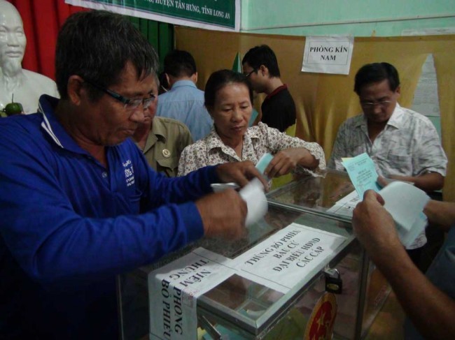 Đông đảo cử tri Tân Hưng đến điểm bầu cử rất sớm mặc dù trời mưa.   Ảnh: Văn Đát