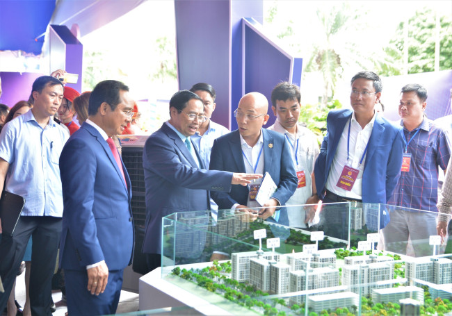 Prime Minister Pham Minh Chinh and leaders visit the product display booth at the Conference announcing investment planning and promotion of Long An