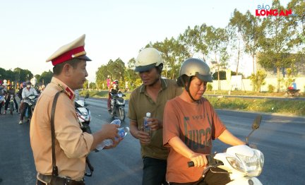 Cảnh sát giao thông và đoàn thanh niên tặng nước suối cho người đi đường