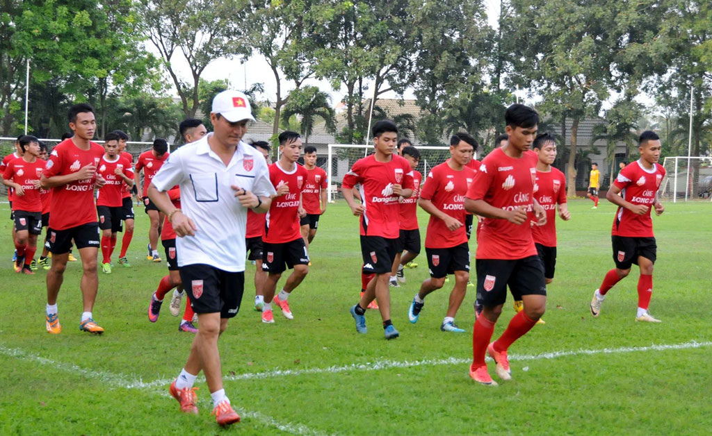 Các cầu thủ tích cực tập luyện trong buổi tập đầu năm dưới sự hướng dẫn của HLV Ngô Quang Sang (áo trắng)”. Ảnh: Anh Tuấn