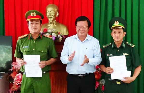 Director of the Department of Industry and Trade Le Minh Duc (C) gives an reward decision to police and army border forces for combating cigarette smuggling in Long An province  