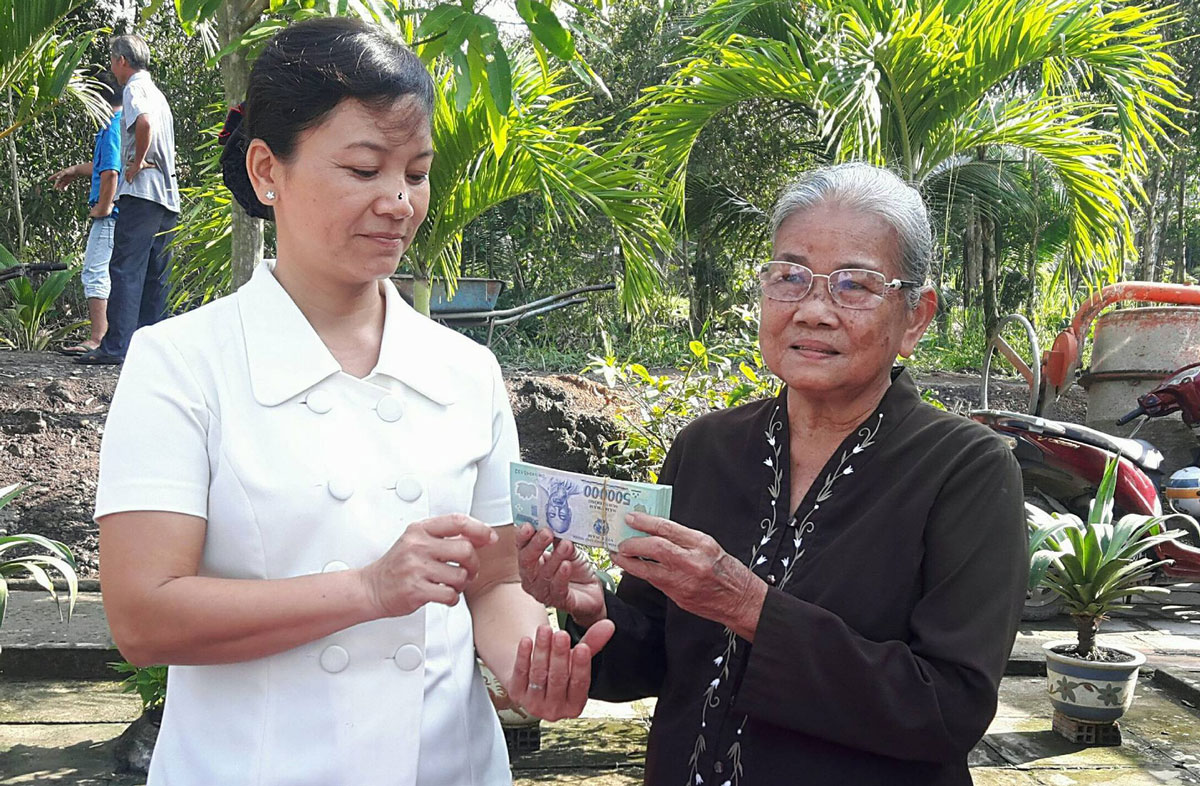 Bà Đặng Thị Xướng (bìa phải) ủng hộ 100 triệu đồng để xây dựng cầu kinh 10 Đời