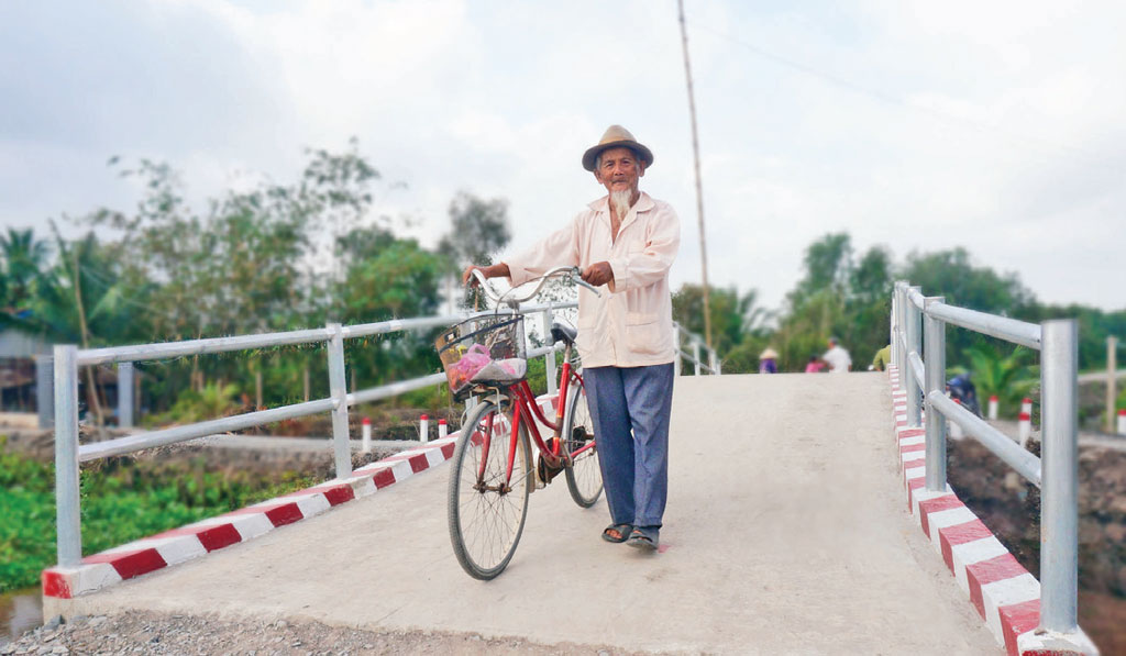 Ông Nguyễn Văn Rắm (84 tuổi), ngụ ấp Hóc Thơm 2, xã Hòa Khánh Tây, huyện Đức Hòa, thong dong dẫn xe qua cầu Kênh Chùa