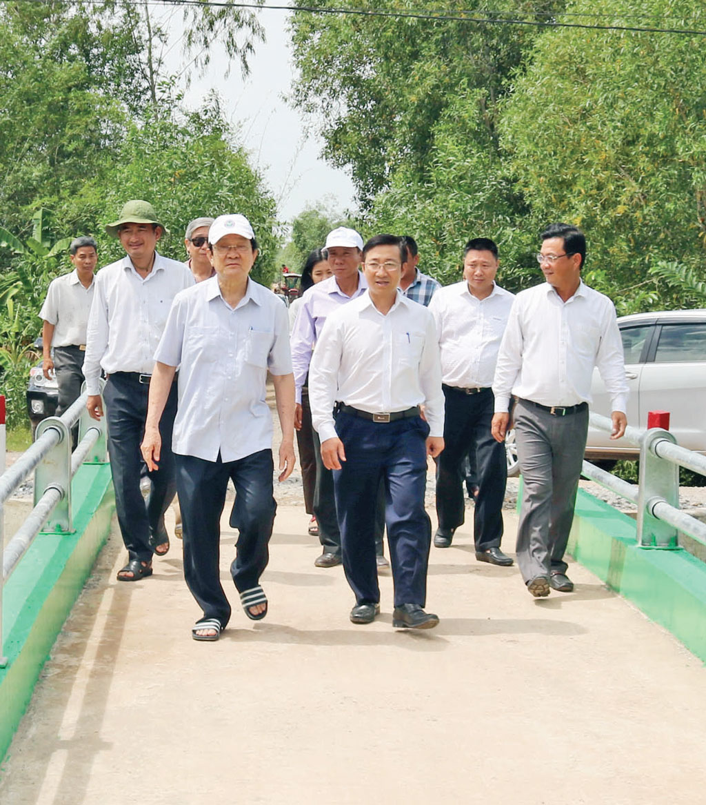 Bác Tư Sang cùng đơn vị tài trợ, đại diện chính quyền địa phương phấn khởi bước đi trên cây cầu vừa hoàn thành, đưa vào sử dụng