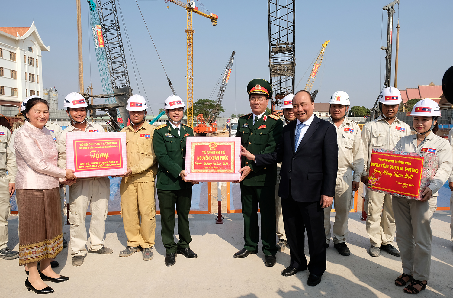 Thủ tướng Nguyễn Xuân Phúc tặng quà đội ngũ cán bộ, công nhân, người lao động đang thi công Nhà Quốc hội mới của Lào - Ảnh: VGP/Quang Hiếu