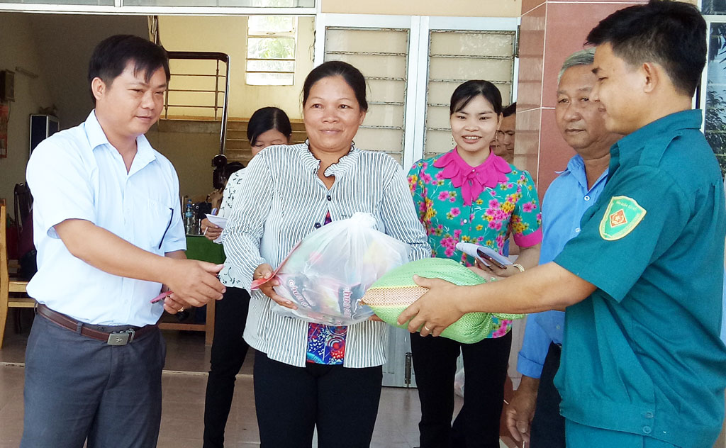 Anh Tuấn (Áo trắng) trao tặng quà cho những hộ nghèo xã biên giới Thuận Bình, huyện Thạnh Hóa