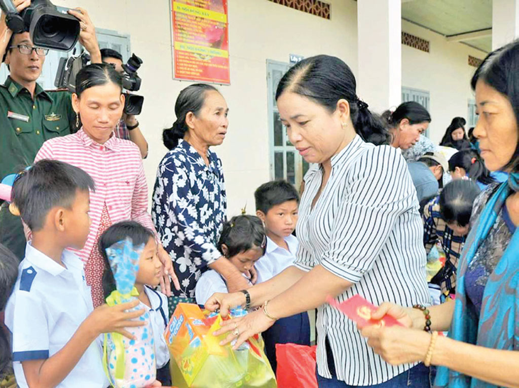 Chị Phạm Út Thủy (thứ hai, phải qua) cùng nhà hảo tâm tặng quà tết cho trẻ em khu vực biên giới