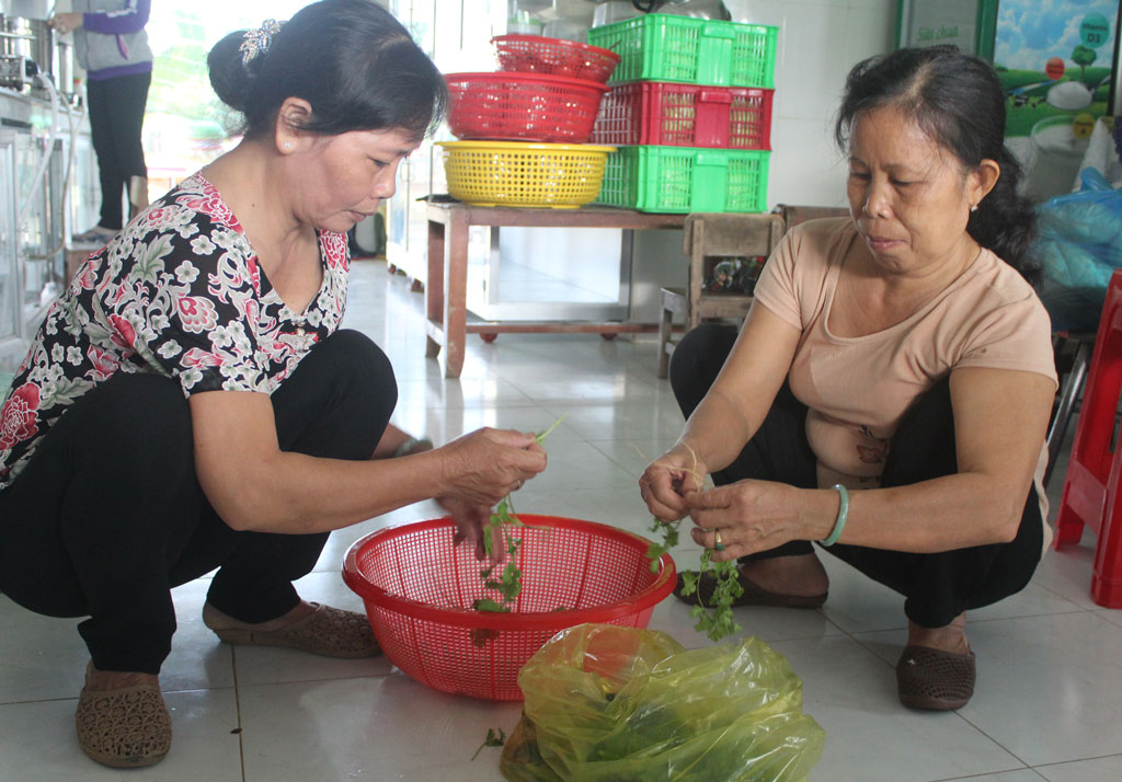Chị Võ Thị Hồng (bìa trái) đang cùng các chị em chuẩn bị bữa cơm cho trẻ tại Trường Mẫu giáo Long Cang