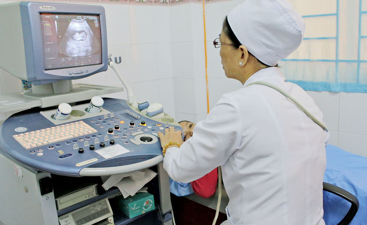 “Gõ cửa” hạnh phúc Phụ nữ trong độ tuổi sinh sản mong muốn có con nên kiểm tra sức khỏe sớm để phát hiện những triệu chứng bất thường (Trong ảnh: Bác sĩ Trung tâm Chăm sóc sức khỏe sinh sản siêu âm cho bệnh nhân)