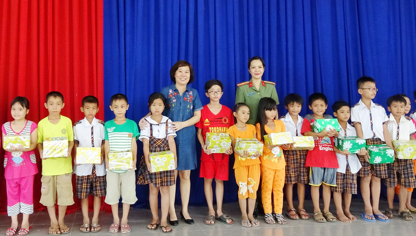 Thiếu tá Đỗ Thị Thúy Hằng - Phó Chủ tịch Hội Phụ nữ Công an tỉnh, trao quà cho học sinh nghèo
