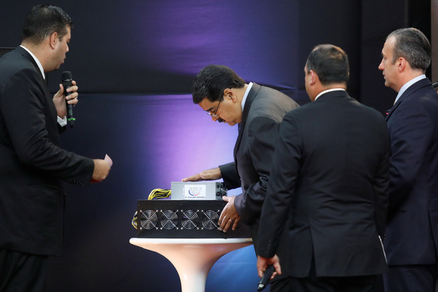 Tổng thống Nicolas Maduro (giữa) xem "máy đào" tiền ảo trong buổi giới thiệu ra mắt đồng Petro tại thủ đô Caracas, hôm 20/2 - Ảnh: Reuters