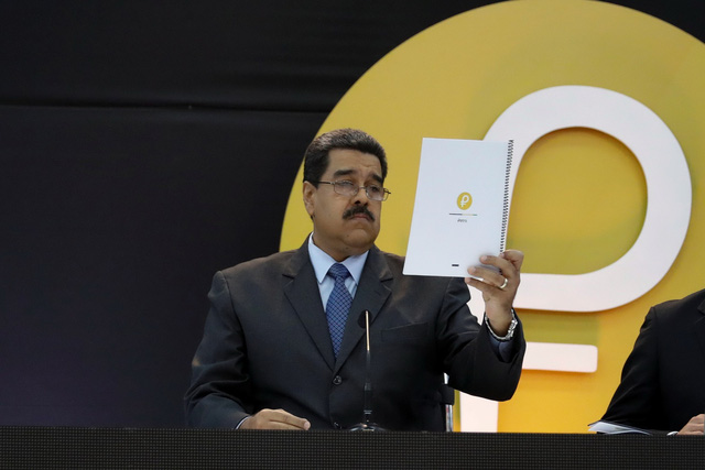 Tổng thống Nicolas Maduro đọc tài liệu giới thiệu ra mắt đồng "Petro" tại thủ đô Caracas, hôm 20/2 - Ảnh: Reuters