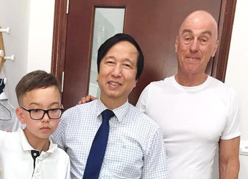 GS Nguyễn Thanh Liêm (giữa) và cha con một bệnh nhi người nước ngoài từng được ông phẫu thuật - Ảnh: NVCC