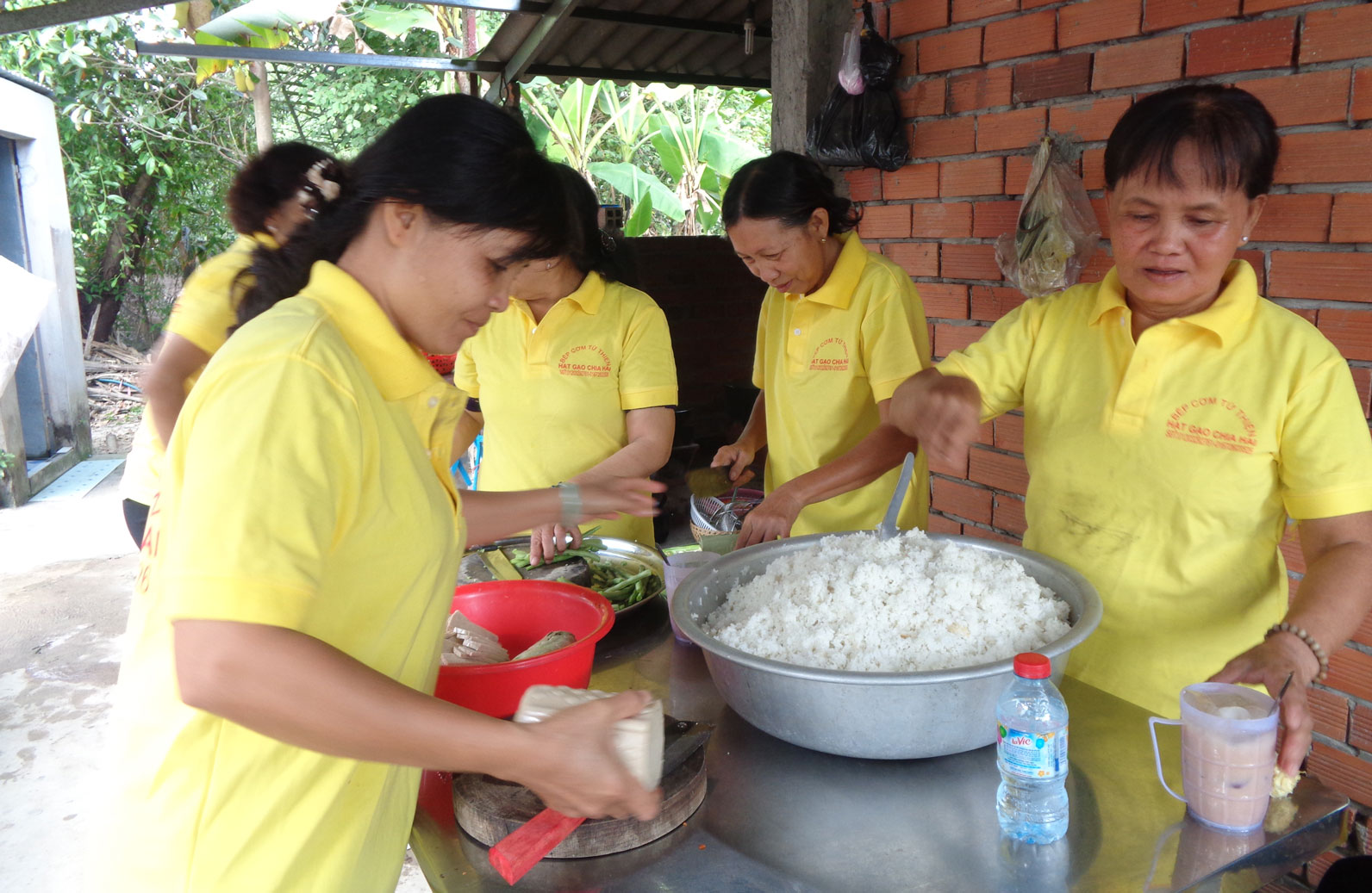 Bà Bùi Thị Phướng (bìa phải) cùng các chị em trong xóm chuẩn bị cơm cho bệnh nhân