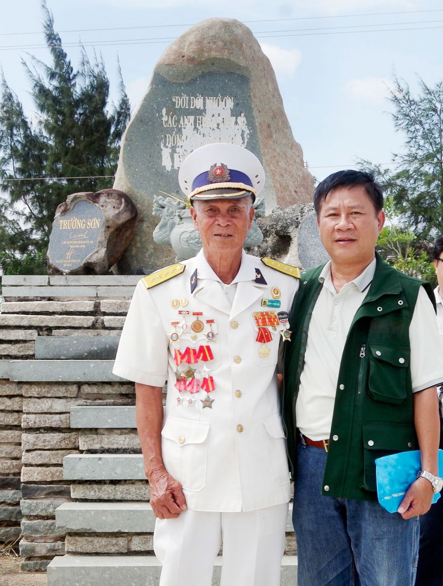 Đại úy Huỳnh Phước Hải - Cựu thủy thủ tàu không số (trái) chụp ảnh lưu niệm tại Công viên Nghĩa trang đường Hồ Chí Minh trên biển