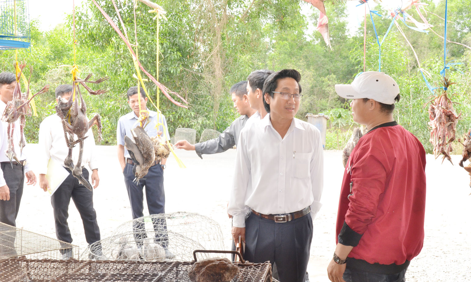 Chủ tịch UBND huyện Thạnh Hóa - Nguyễn Văn Tạo (hàng đầu, thứ 2, phải qua) nắm tình hình mua bán tại điểm bán hàng nông sản