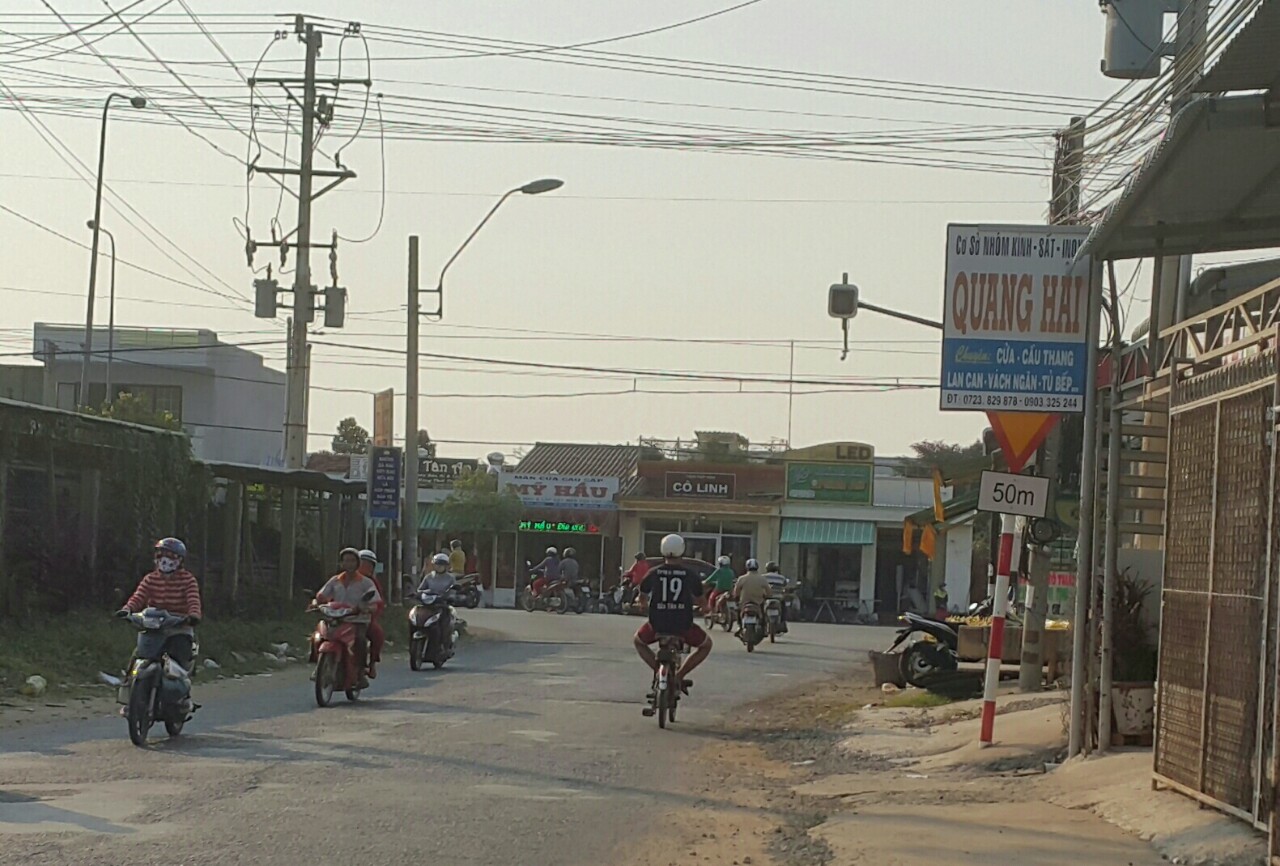 Biển báo nguy hiểm  ngã ba Nguyễn Văn Tiếp-QL1 (phường 5, TP Tân An) bị bảng hiệu che khuất một phần.