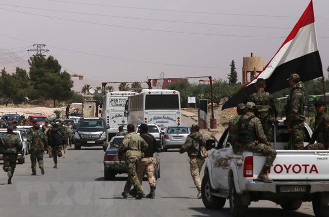 Binh sĩ Syria giám sát việc sơ tán của phiến quân khỏi khu vực Douma ngày 09/4 vừa qua. (Ảnh: AFP/TTXVN)