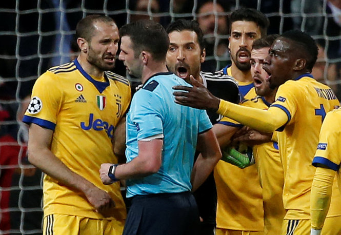 Trọng tài Oliver (thứ 2 từ trái sang) bị phản ứng dữ dội trong trận R.M - Juventus. Ảnh: Reuters