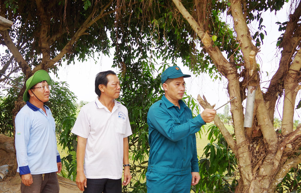 Gương sáng “sao vuông” Dân quân Nguyễn Văn Phụng hướng dẫn người dân sử dụng kẻng báo động khi có sự cố xảy ra