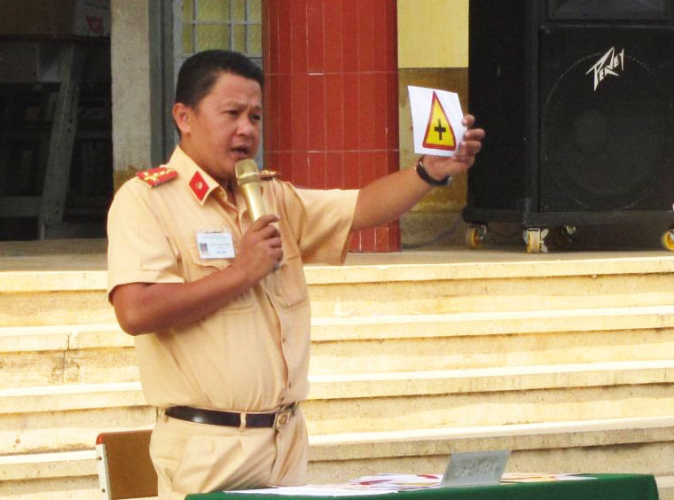 Cán bộ Đội CSGT huyện Châu Thành đang tuyên truyền về TTATGT cho các em học sinh.