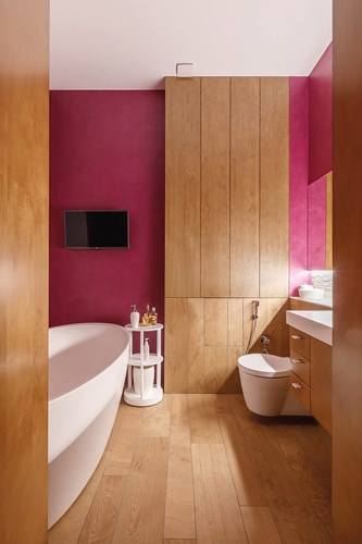 Đối lập với việc trang trí đơn giản trong phòng ngủ, nhà tắm bên cạnh rực rỡ hơn bằng những gam màu nổi bật trang trí trên tường, phần sàn gỗ đã được xử lý để không bị không khí ẩm trong nhà tắm làm ảnh hưởng đến chất lượng sàn.