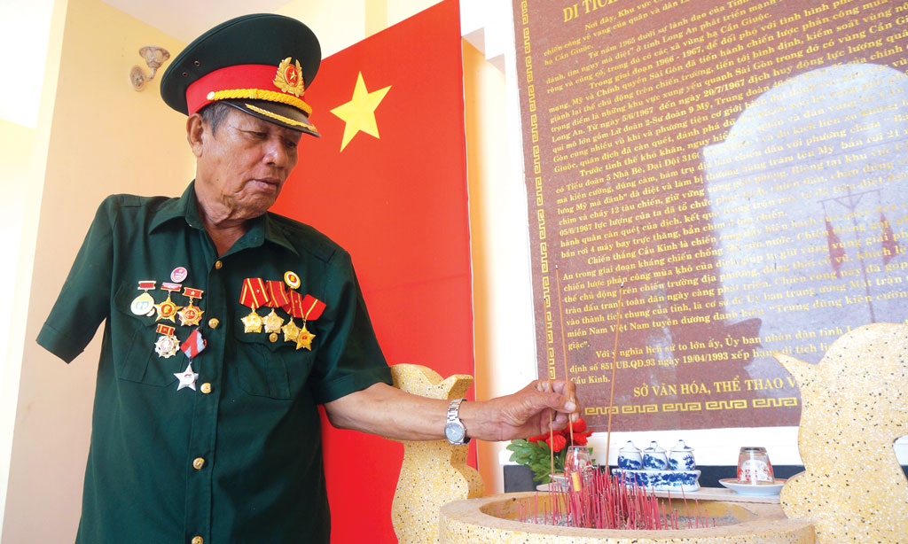 Ông Nguyễn Văn Kiểm thắp nhang cho các đồng đội  hy sinh tại khu di tích lịch sử cầu Kinh