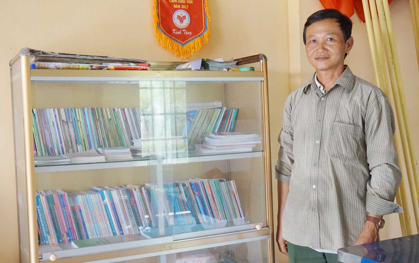 Trưởng ấp Cầu Tràm - Bùi Quang Trung bên tủ sách pháp luật