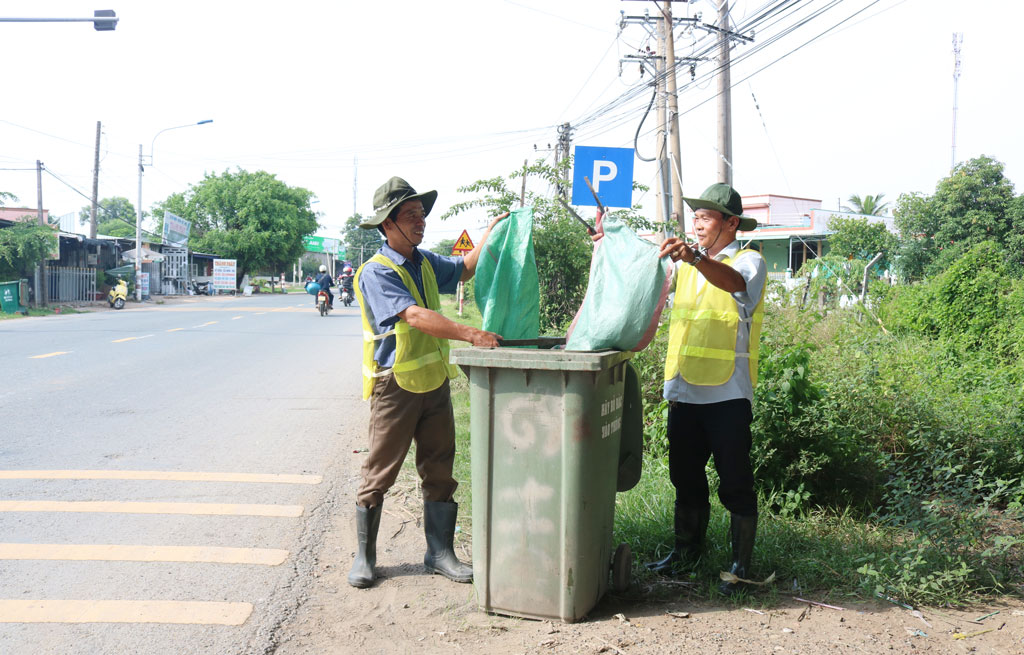 Người dân xã Thanh Phú, huyện Bến Lức tự giác xuống đường nhặt rác. Ảnh: Thanh Mỹ