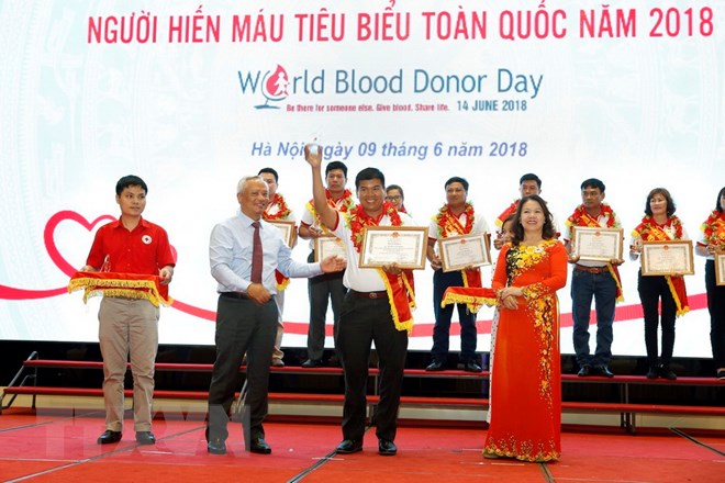 Phó Chủ tịch Quốc hội Uông Chu Lưu và Chủ tịch Hội Chữ thập đỏ Việt Nam Nguyễn Thị Xuân Thu tôn vinh người hiến máu tình nguyện tại Lễ tôn vinh 100 người hiến máu tình nguyện năm 2018. (Ảnh: Dương Ngọc/TTXVN)