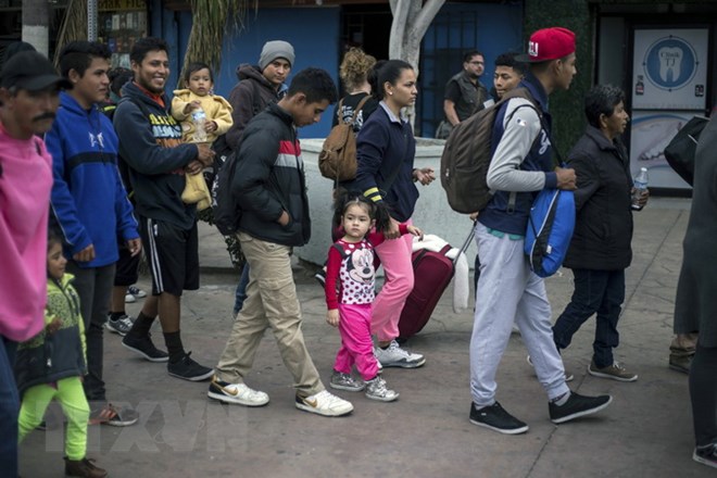 Người di cư tìm kiếm khả năng nhập cư vào Mỹ, chờ đợi tại khu vực Tijuana thuộc biên giới Mỹ-Mexico. (Nguồn: AFP/TTXVN)