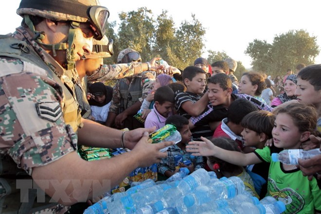 Binh sĩ Jordan phân phát nước uống và lương thực cho người tị nạn Syria tại khu vực Ramtha ở biên giới Syria-Jordan ngày 5/9/2012. (Nguồn: AFP/TTXVN)