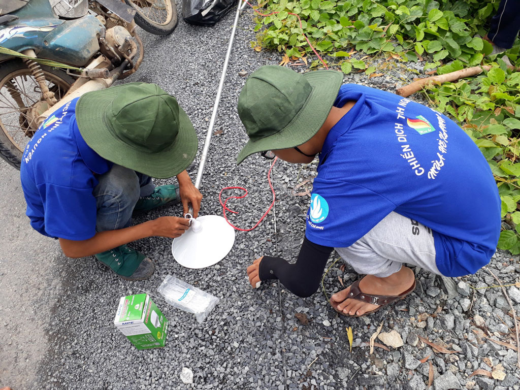 Các chiến sĩ tình nguyện tham gia mắc đèn chiếu sáng đường giao thông nông thôn tại mặt trận Bình Hòa Nam, huyện Đức Huệ