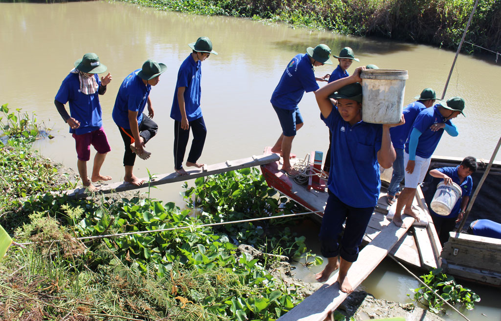 Các chiến sĩ tình nguyện tham gia trải đá xanh tuyến đường Kênh T6 nối ấp Mương Khai với Tân Thiết, huyện Mộc Hóa