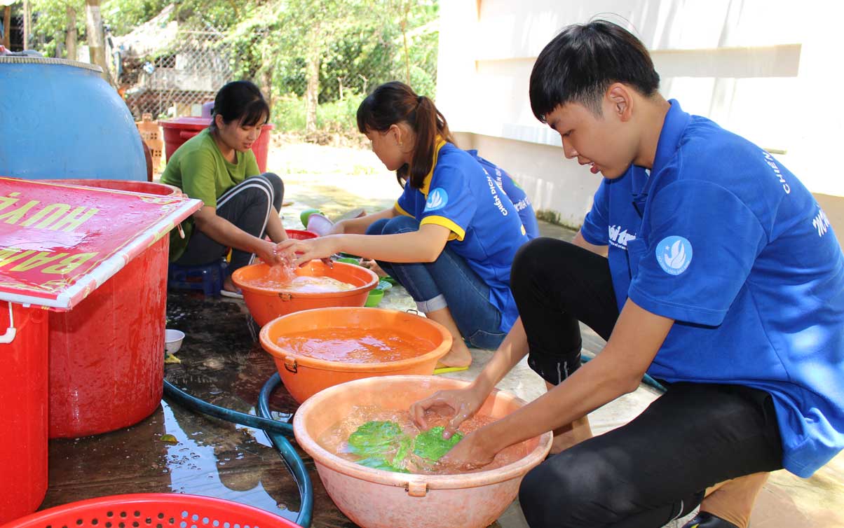 Trang cùng các bạn trong tổ hậu cần rửa chén sau bữa ăn trưa