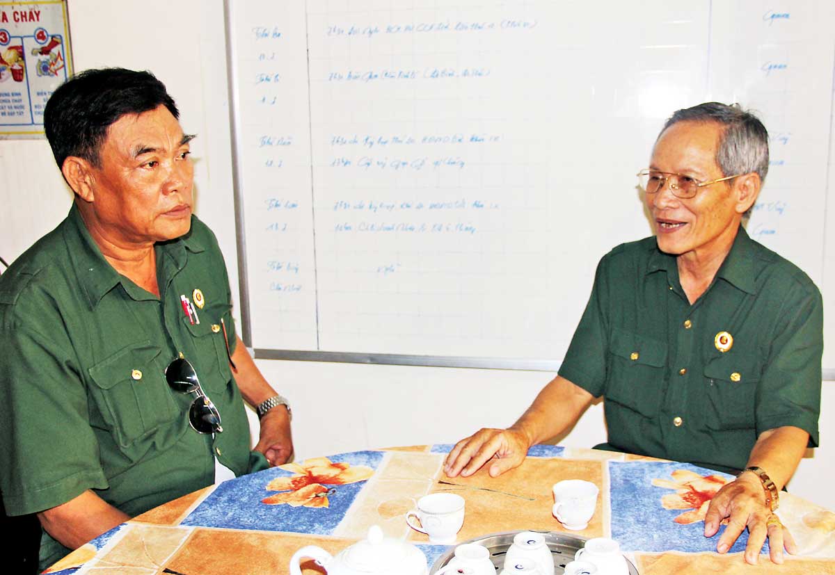 Cựu chiến binh Phùng Văn Minh (bên phải) trò chuyện cùng đồng đội khi nhắc những ký ức về cuộc chiến tranh biên giới Tây Nam
