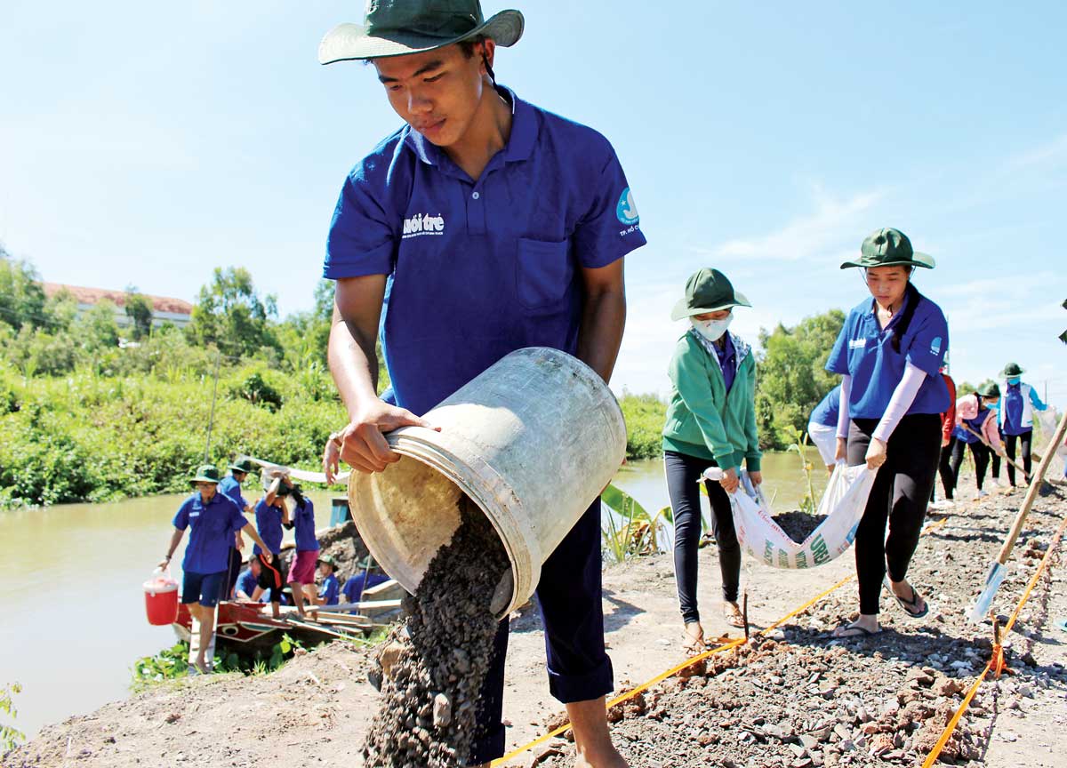 Chiến sĩ thanh niên tình nguyện giúp dân trải đá xanh đường giao thông nông thôn