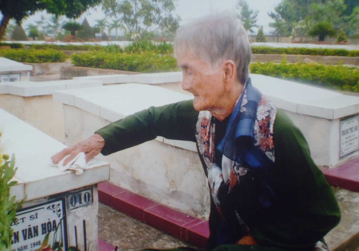 Mẹ Việt Nam Anh hùng Trần Thị Muôn chăm sóc mộ con