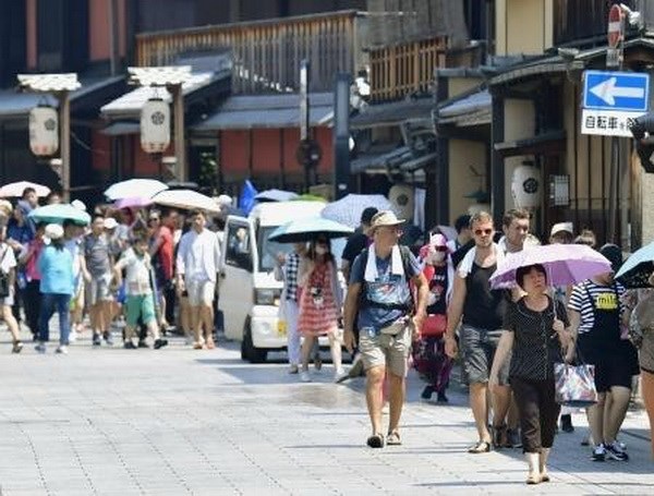Người dân che ô tránh nắng tại Kyoto, Nhật Bản ngày 19/7. (Ảnh: Kyodo/TTXVN)