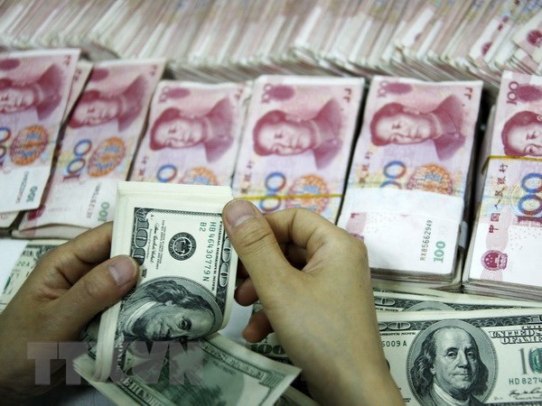 Đồng tiền giấy 100 USD (trên) và đồng 100 Nhân dân tệ (phía dưới) tại một ngân hàng ở Hoài Bắc, tỉnh An Huy, Trung Quốc. (Nguồn: AFP/ TTXVN)