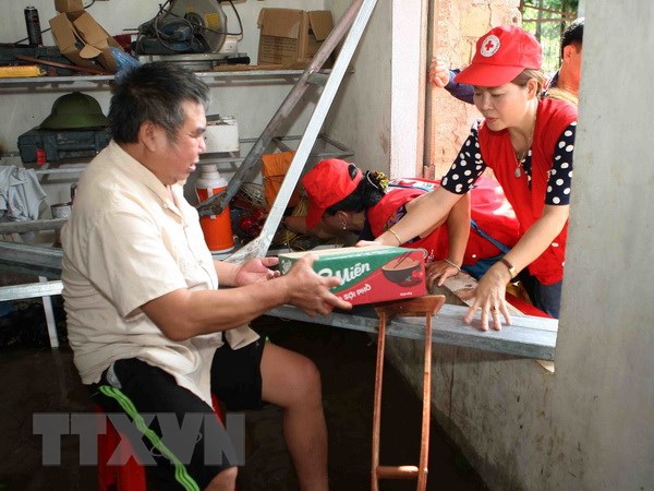 Cán bộ Hội Chữ thập Đỏ thành phố Hà Nội trao quà hỗ trợ người dân xã Tân Tiến, huyện Chương Mỹ, Hà Nội. (Ảnh: Thanh Tùng/TTXVN)
