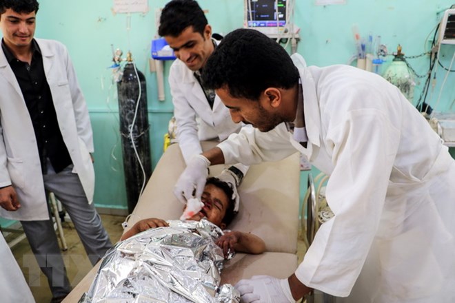 Nhân viên y tế điều trị cho một em nhỏ bị thương trong vụ không kích ở Saada. (Ảnh: AFP/TTXVN)