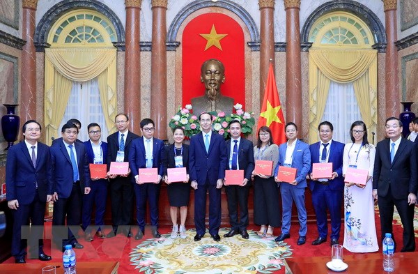Chủ tịch nước Trần Đại Quang tặng logo chân dung Chủ tịch Hồ Chí Minh cho các đại biểu tại buổi gặp mặt. (Ảnh: Nhan Sáng/TTXVN)
