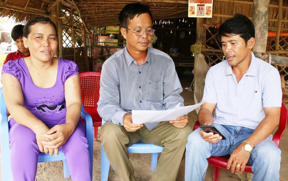 Anh Nguyễn Văn Lôi (giữa) trao đổi công việc với người dân địa phương