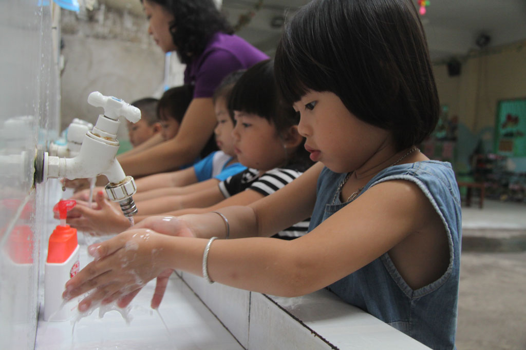 Hướng dẫn trẻ cách rửa tay bằng xà phòng để phòng, chống dịch bệnh. Ảnh: Ngọc Thạch