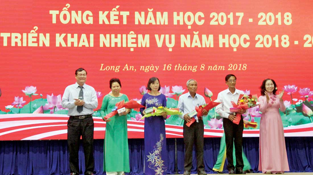 Giám đốc Sở Giáo dục và Đào tạo - Nguyễn Thanh Tiệp (bìa trái) tặng hoa, quà cho cán bộ về hưu của ngành nhân dịp tổng kết năm học