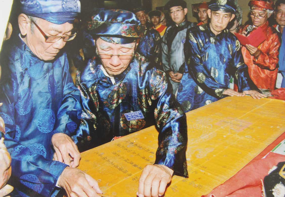 Đình thần - Nơi lưu giữ nét văn hóa truyền thống: Bài 1 - Tìm về nguồn cội Mỗi năm, sắc phong chỉ được mở ra một lần, mỗi lần thỉnh sắc đều phải áo dài, khăn đóng chỉnh tề. (Trong ảnh: Mở sắc phong đình Vĩnh Phong)